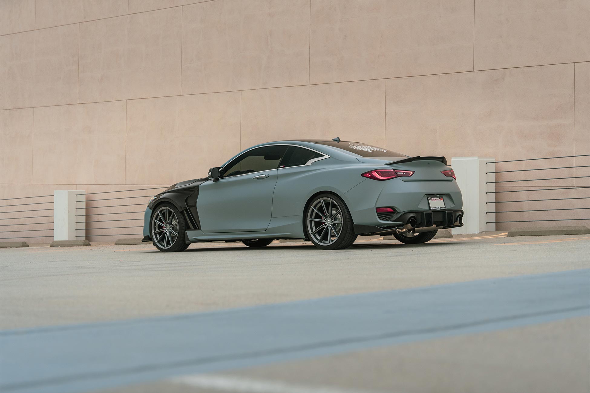 A modified Infiniti Q60 with carbon fiber front fenders and Curva Concepts C46 aftermarket wheels