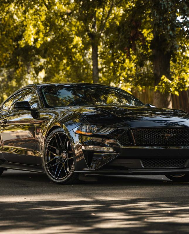 An image of a black Ford Mustang 5.0 with staggered 20 inch Curva Concepts wheels
