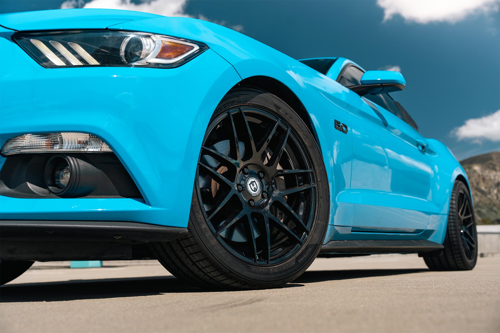 An image of a blue Ford Mustang GT on staggered19 inch Flow Forged Curva Concepts CFF300 aftermarket wheels