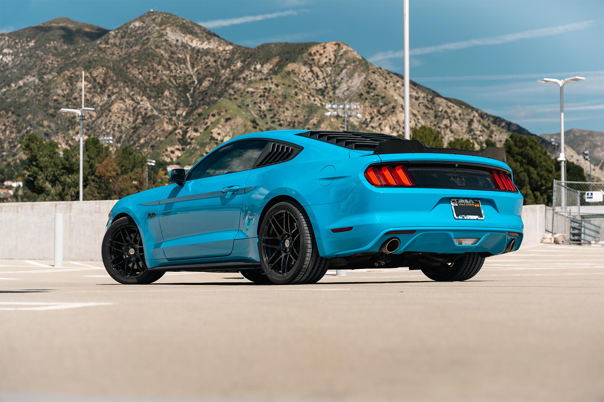 An image of a blue Ford Mustang GT on staggered19 inch Flow Forged Curva Concepts CFF300 aftermarket wheels