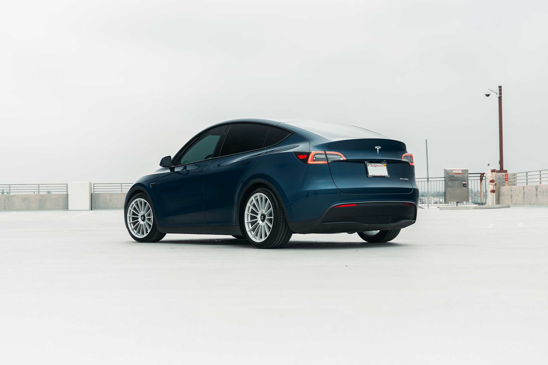 deep blue metallic tesla model y with flow forged cff75 center lock style lightweight performance wheels