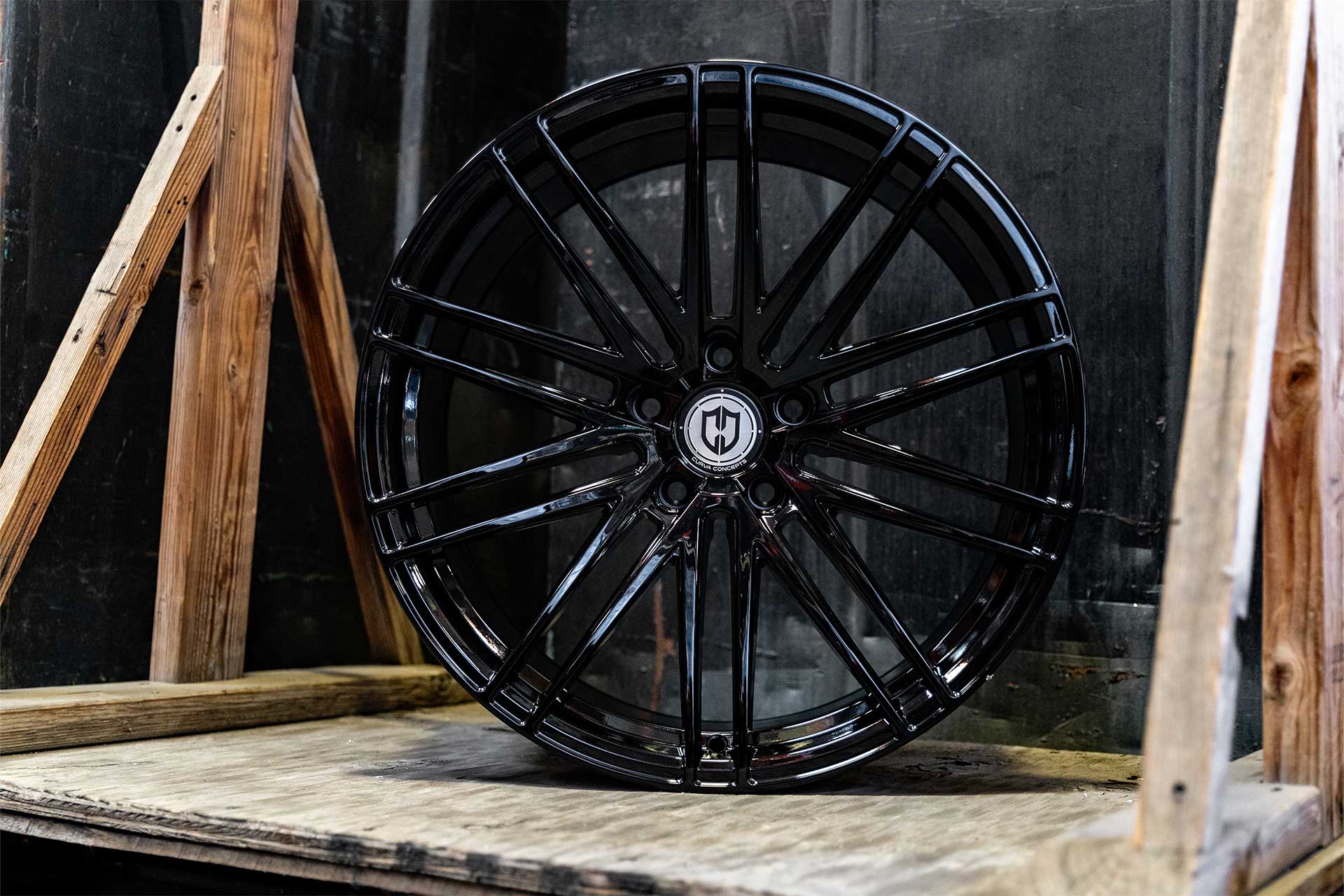 front shot of a gloss black curva concepts cff50 wheel on wooden pallet