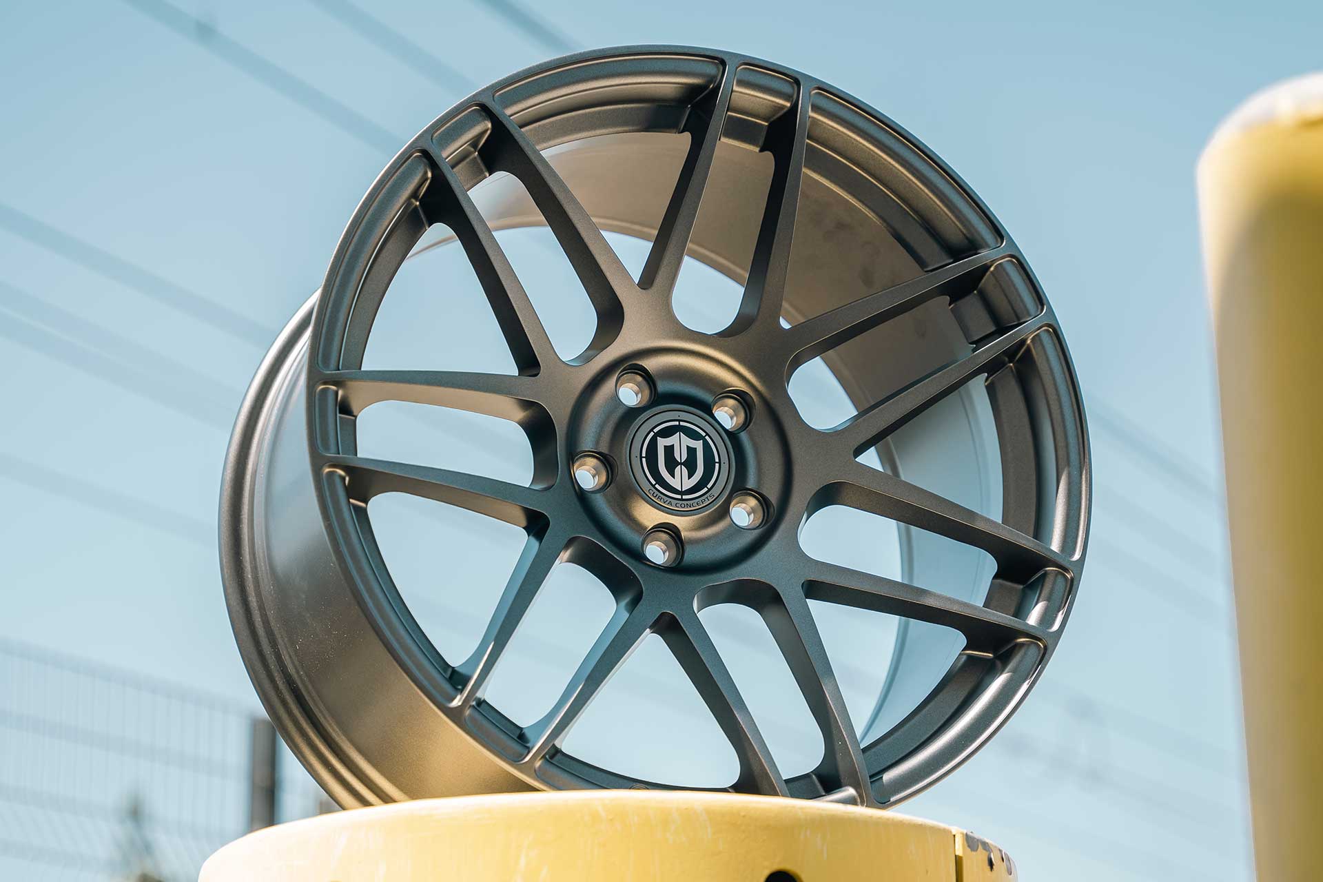 close up shot from below of a gunmetal curva concepts cff300 wheel on top of a yellow can